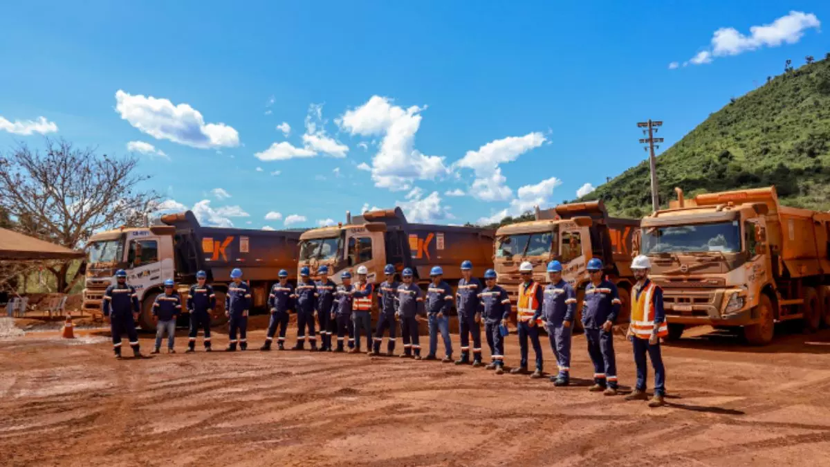 A foto mostra uma frota de caminhões do Grupo K e vários motoristas