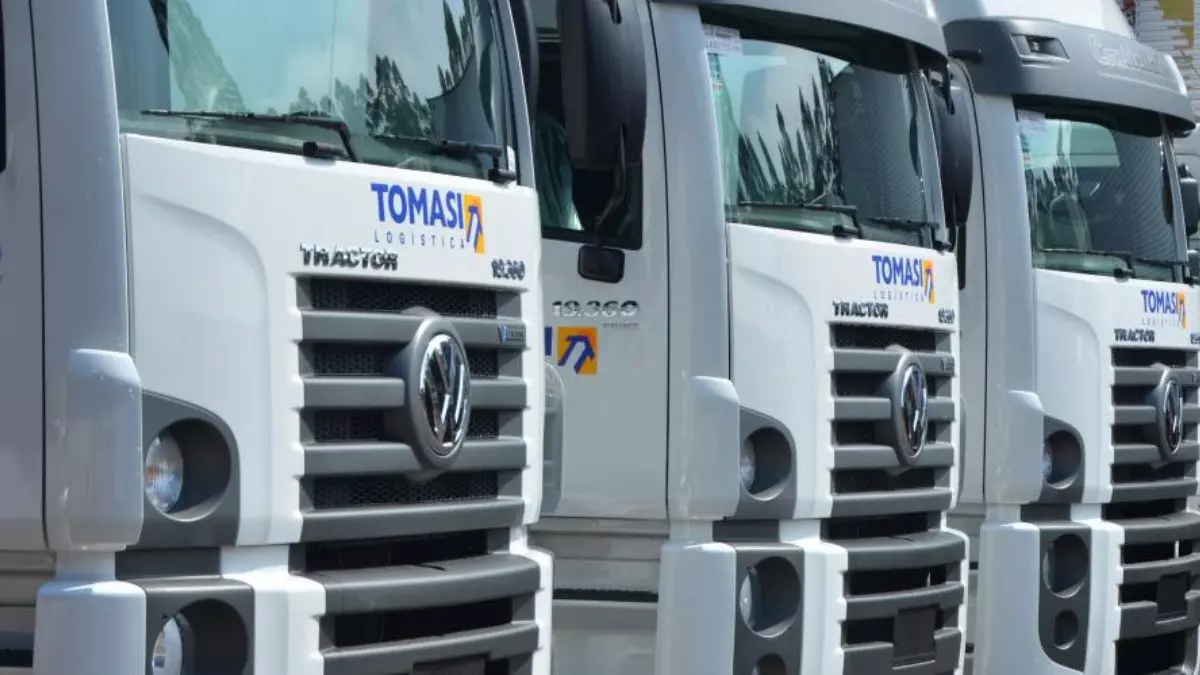 A foto mostra uma frota de caminhões da Tomasi Logística