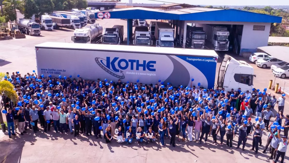 A foto mostra uma carreta da Kothe e os funcionários da empresa levantando balão azul