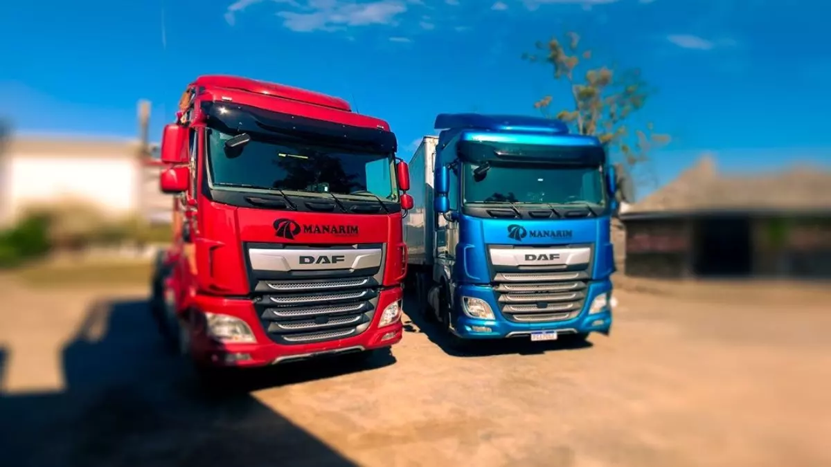 A foto mostra 2 caminhões da Manarim Transportes
