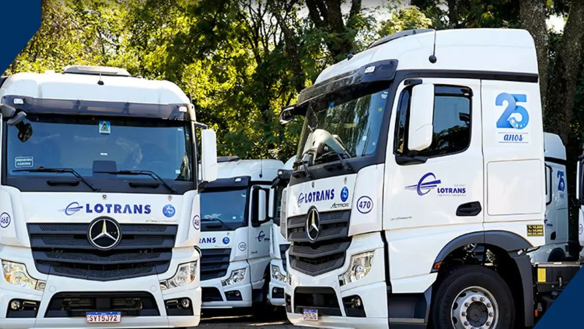 A foto mostra uma frota de caminhões da Lotrans