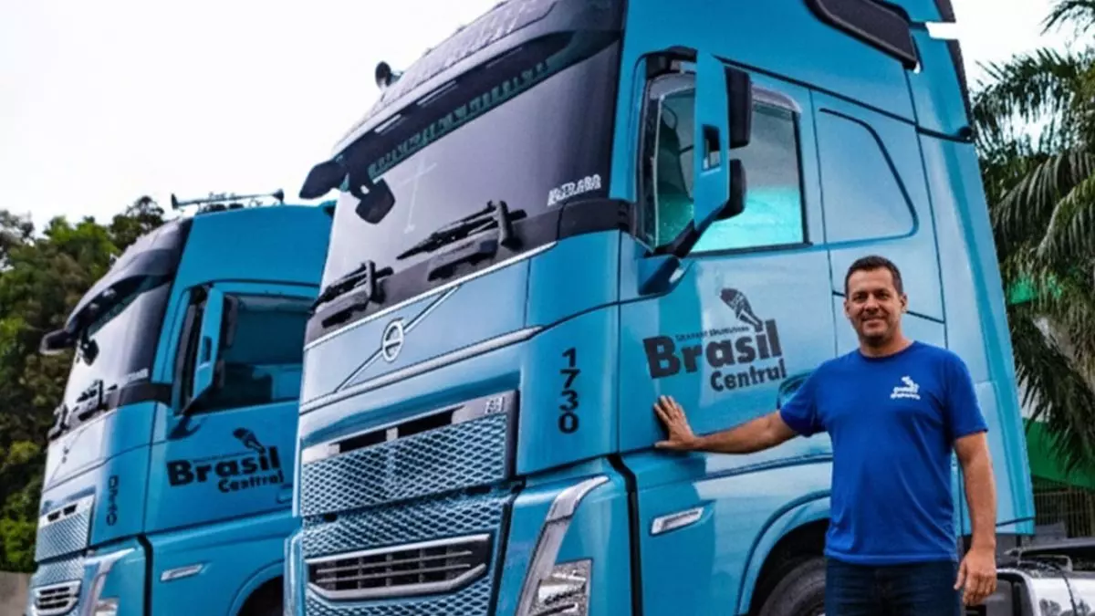 A foto mostra 2 caminhões e 1 motoristas da Transportadora Brasil Central