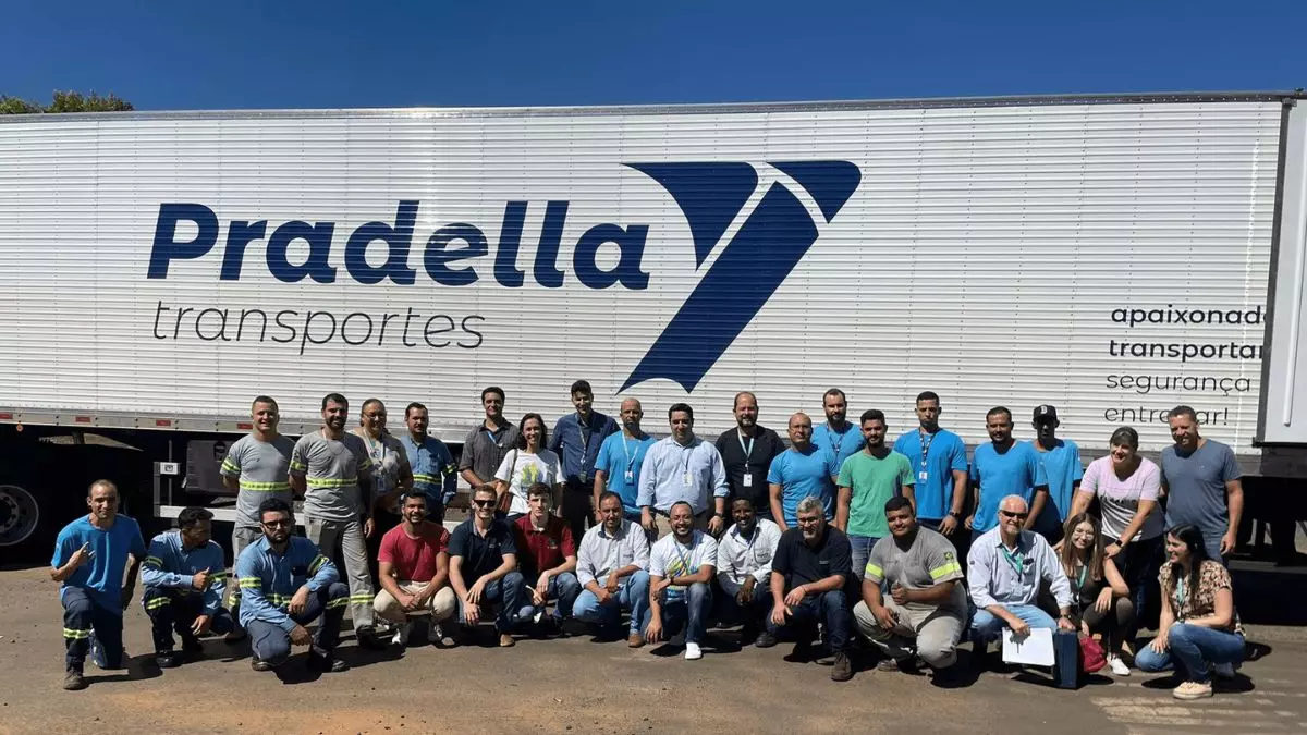 A foto mostra uma carreta da Pradella Transportes e vários funcionários da empresa