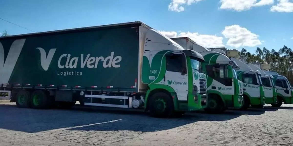 A foto mostra uma frota de caminhões truck da Cia Verde