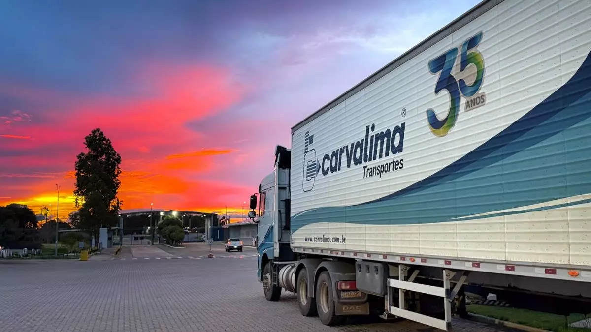 A foto mostra uma carreta da Carvalima Transportes no pátio da empresa ao entardecer