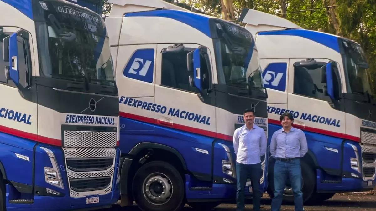 A foto mostra uma frota e funcionários da Expresso Nacional