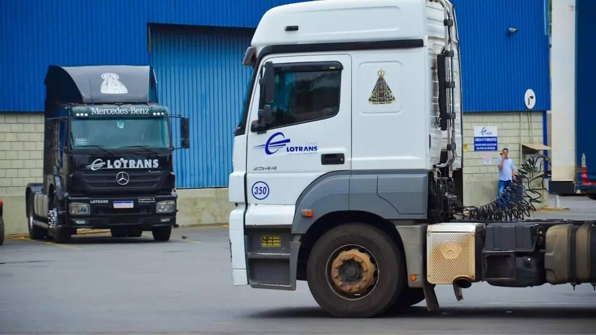 A foto mostra dois caminhões da Lotrans Transportes
